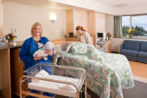 nurse holding baby in hospital room
