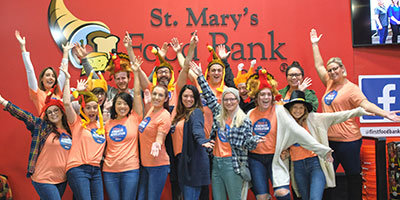 group celebrating in front of St. Mary's food bank sign