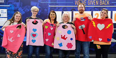 group holding up superhero capes